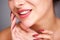 Partial portrait of woman smiling with red manicure and flawless complexion