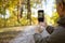 Partial shot of blurred tourist taking photo of forest on smartphone