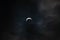 Partial solar eclipse - moon covers sun, dark clouds, celestial drama - crescent sun - atmospheric mood