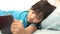 Partial view of Asian little girl using tablet in bed at home, mobile gadget addiction on children
