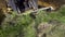 Partial view of bulldozer removing layer of grassy soil during earth works