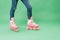 Partial view of child wearing denim and pink rollerblades isolated