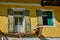 Partial view of a destroyed old house with broken windows and shutters and a broken balcony