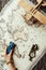 partial view of female hand with toy car, compass, wooden toy plane and map