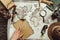 partial view of male hand, map, blank burnt paper, watch, magnifying glass, compass and hat on wooden