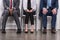 partial view of multiethnic business people sitting on chairs while waiting