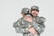 partial view of smiling soldier and son in military uniforms hugging each other