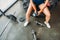 partial view of sportswoman in wristbands sitting with bottle of water and jump rope on training tire