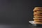 Partial view of a stack of gingerbread cookies on a white plate with a black background