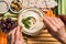 partial view of woman and arranged hummus in bowl pita bread cut vegetables dried tomatoes