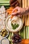 partial view of woman and arranged hummus in bowl pita bread cut vegetables dried tomatoes