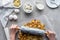 partial view of woman crushing cookies with rolling pin for pie