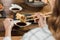 Partial view of woman dipping sushi in soy sauce with chopsticks