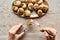 Partial view of woman eating delicious cooked escargots with tweezers on stone background.