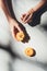 partial view of woman holding piece of apricot on light