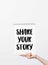 partial view of woman holding sketchbook with Share your story lettering