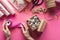 Partial view of woman holding spool of ribbon near gift box with silver hearts and valentines handiwork supplies on pink