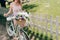 partial view of woman in stylish dress with retro bicycle with wicker basket full of flowers