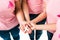 partial view of women in pink t-shirts holding breast cancer awareness ribbon