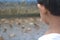 Partially blurred portrait of a child looking at ducks swimming