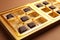 Partially empty box of chocolate candies on brown background, closeup