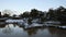 Partially frozen pond in snow covered Japanese garden at dawn