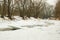 Partially frozen river with stony riverbank