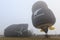 Partially inflated hot air balloons on a foggy day