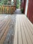 Partially painted wooden deck with wooden railings.