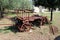 Partially restored old vintage retro horse wagon with broken parts and wooden boards used as garden decoration surrounded with