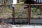 Partially rusted metal front entrance doors with bunch of newspapers and flyers leading to abandoned house driveway