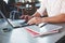 Particle view of freelance man working on the project with laptop and notepads on table