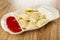 Partitioned dish with dumplings, sour cream and ketchup on table