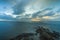 Partly clouded sunrise over tidal waters, mudflats and rocks