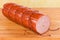 Partly cut boiled smoked sausage on cutting board close-up