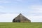 A partly demolished hut on a grass field on wadden sea island Texel in the Netherlands with a beautiful blue sky