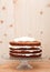 Partly frosted cake on a glass stand, decoration in process