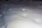 Partly lightened surface area covered with fluffy snow at night