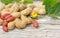 Partly peeled peanuts with leaves and flowers on wooden surface