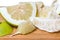 Partly peeled pieces of ripe pomelo on wooden cutting board