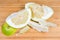 Partly peeled pieces of ripe pomelo on wooden cutting board