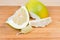 Partly peeled ripe pomelo on a wooden cutting board