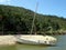 A partly sunken old yacht in a river estuary