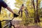 Partner cyclist, looks like performs jumps and stunts with a bike. in the forest against the setting sun