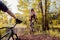 Partner cyclist, looks like performs jumps and stunts with a bike. in the forest against the setting sun