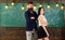 Partners concept. Man with beard and girl teacher stand in classroom, chalkboard on background. Lady and hipster