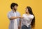 Partnership and collaboration work as team. Young indian woman and man making fist bumps, posing on yellow background