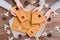 Parts of a disassembled Christmas gingerbread house in children`s hands and Christmas decorations on a wooden background. Top vie