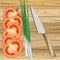 Parts of tomato, green onion and knife on wooden table surface.