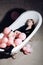 Party balloons in bubbles bath tub. woman relax in bath. fashion model in autumn coat. hygiene and spa treatment. having